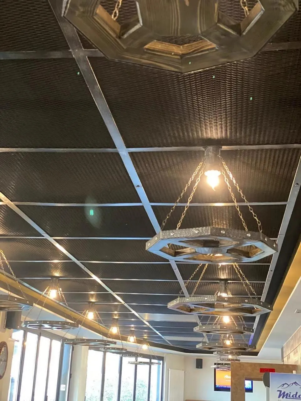 Restaurant ceiling with steel grid and hand-made iron and timber pendant lights