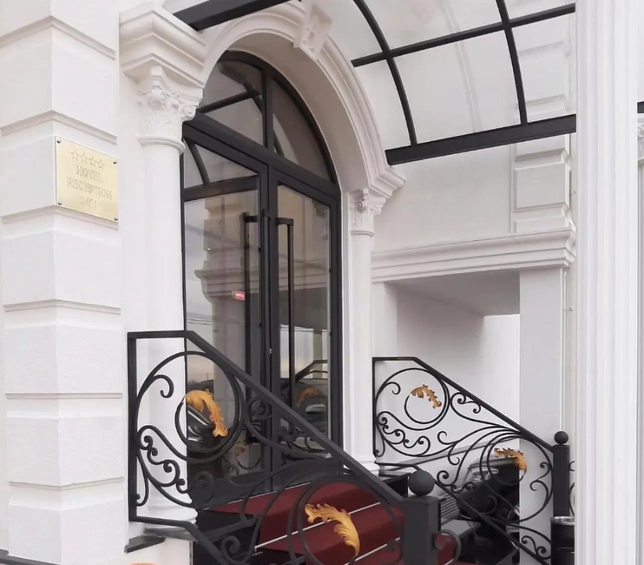 Hand-forged black scroll balustrades with gilded acanthus leaves on hotel entrance steps